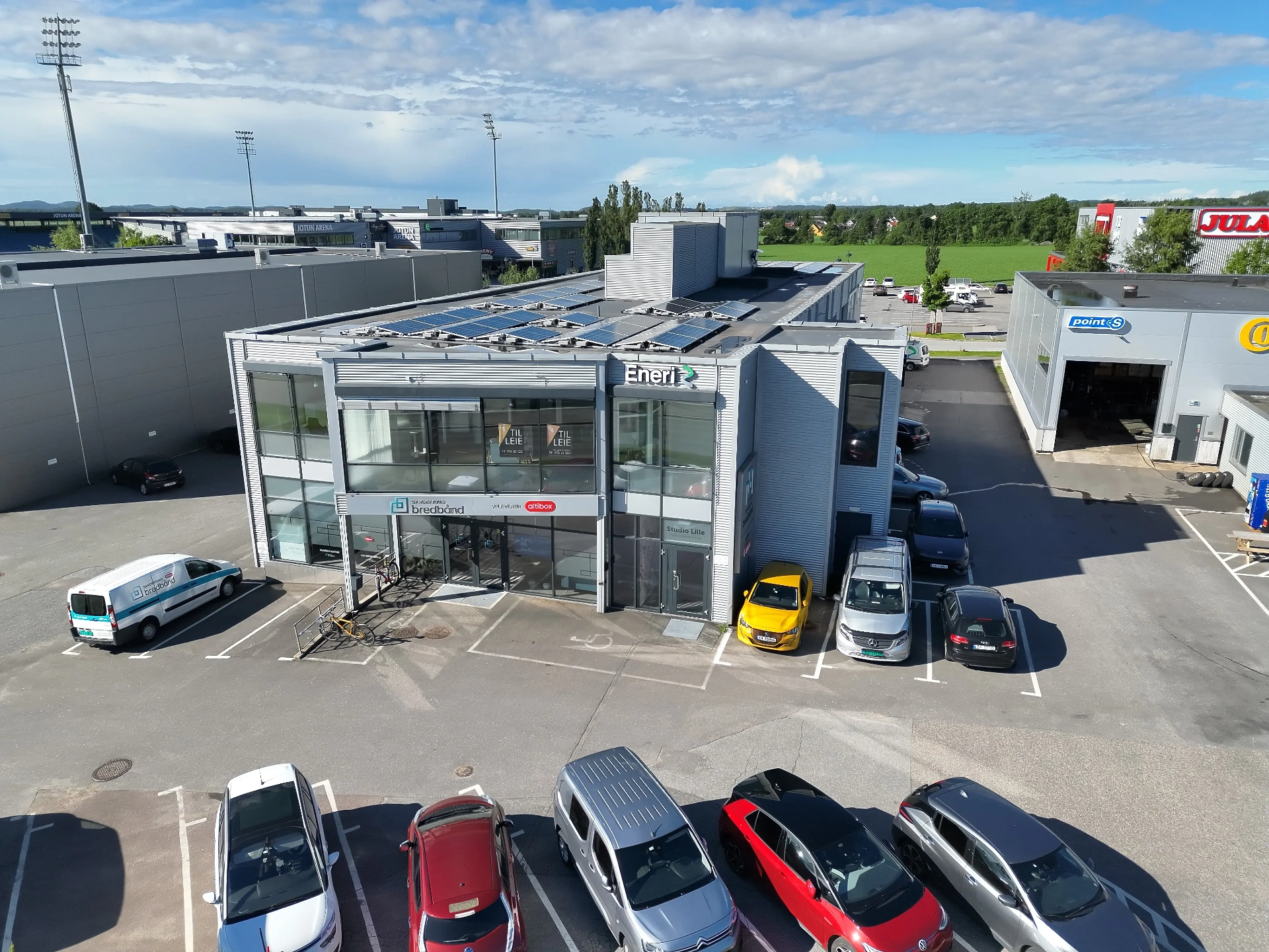 Nygårdsveien 80 sett fra parkeringen, med Sandefjord Bredbånd og Eneri i fasaden